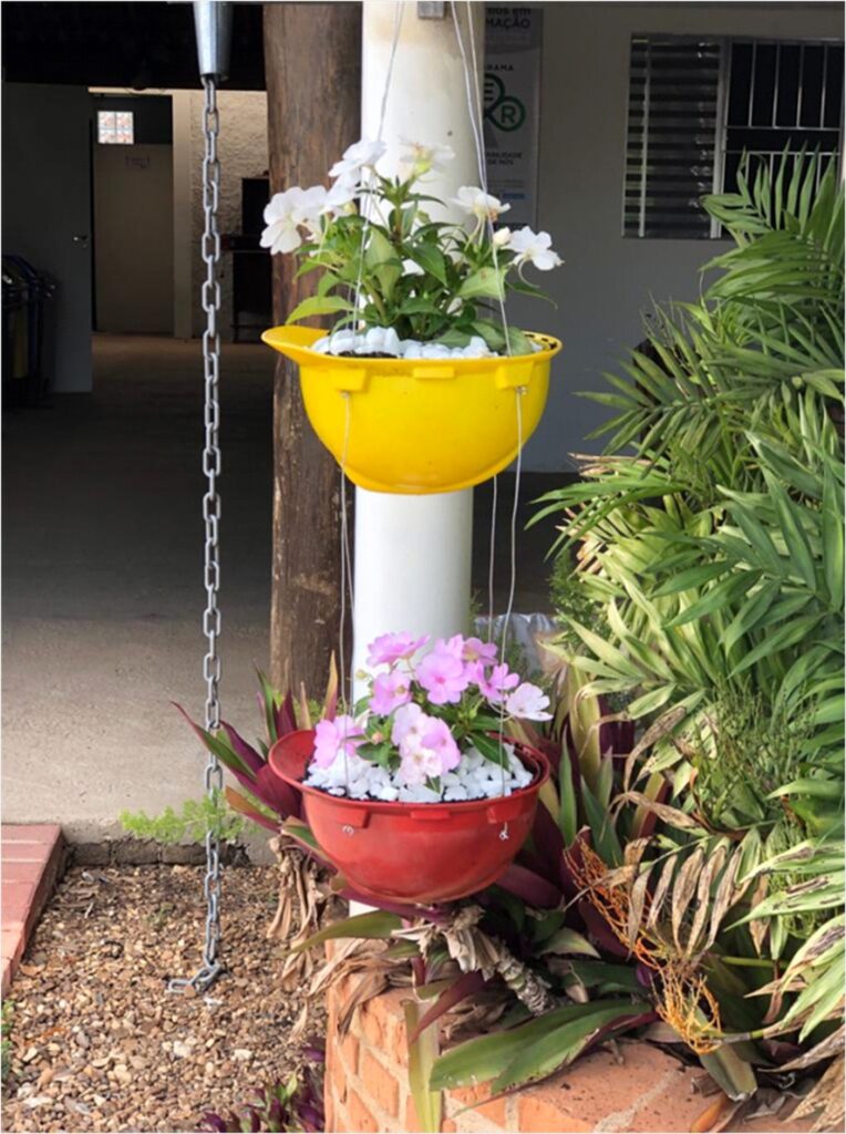 Capacetes de segurança danificados como vasos para plantio de flores